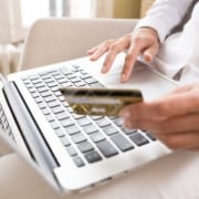 Kvinde ved computer med kreditkort i hånden