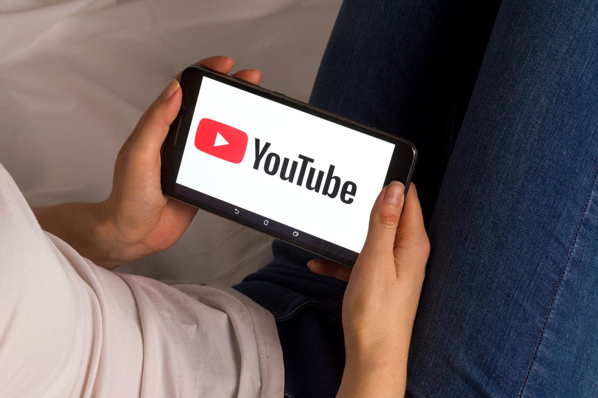 Kvinde der ser YouTube video på telefon